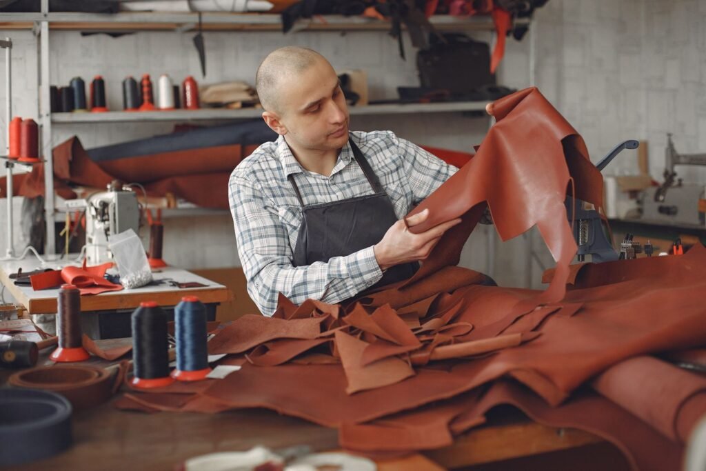 Focused artisan in a workshop checking leather material for quality