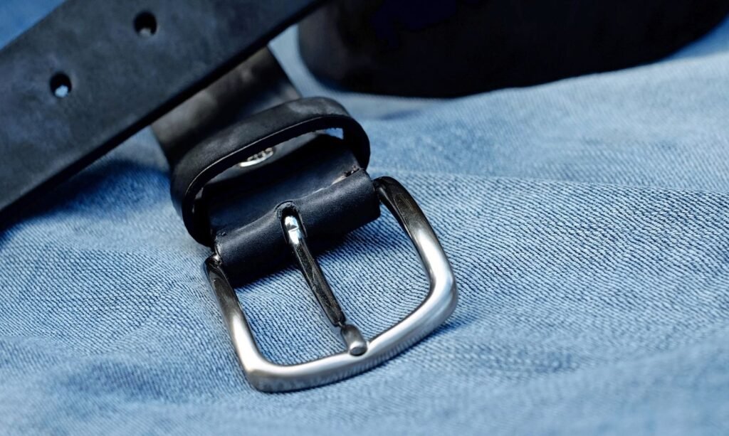 Close-up of a black leather belt with a metal buckle