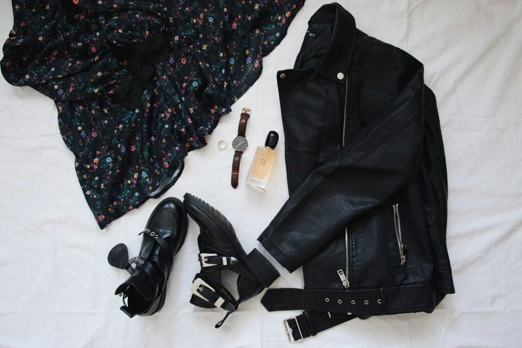 Black leather belt arranged on white textile for a minimalist flatlay