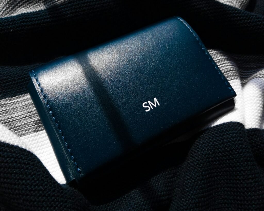 Black leather bifold wallet resting on a black textile surface