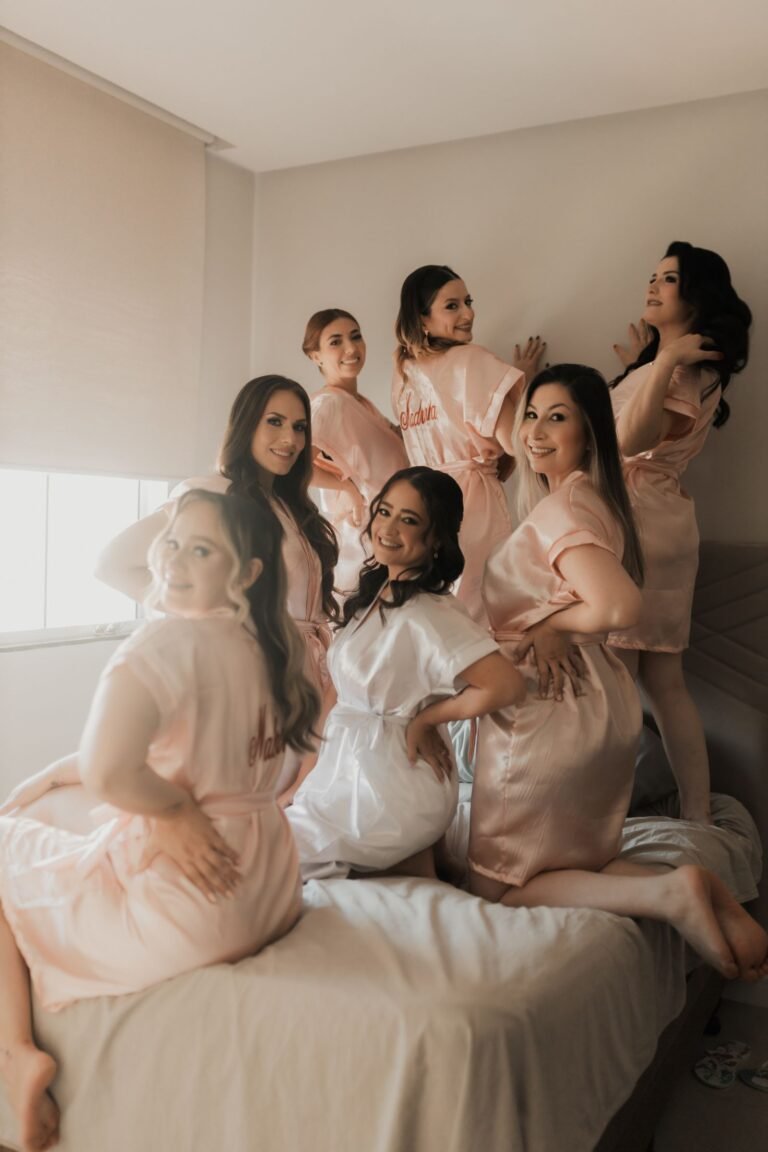 Group of bridesmaids in matching robes enjoying pre-wedding preparations indoors