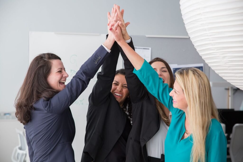 Group of enthusiastic businesswomen achieving a success with a high five