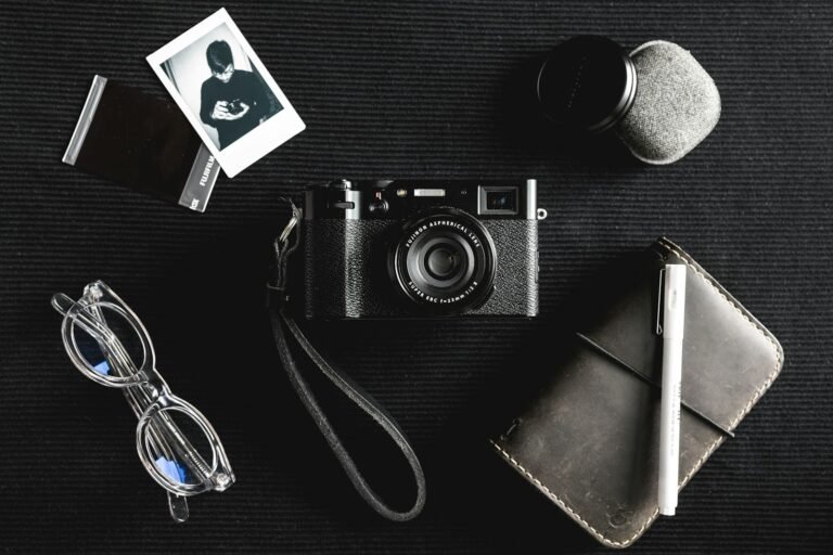 Camera and a black leather bifold wallet arranged as an everyday carry flatlay