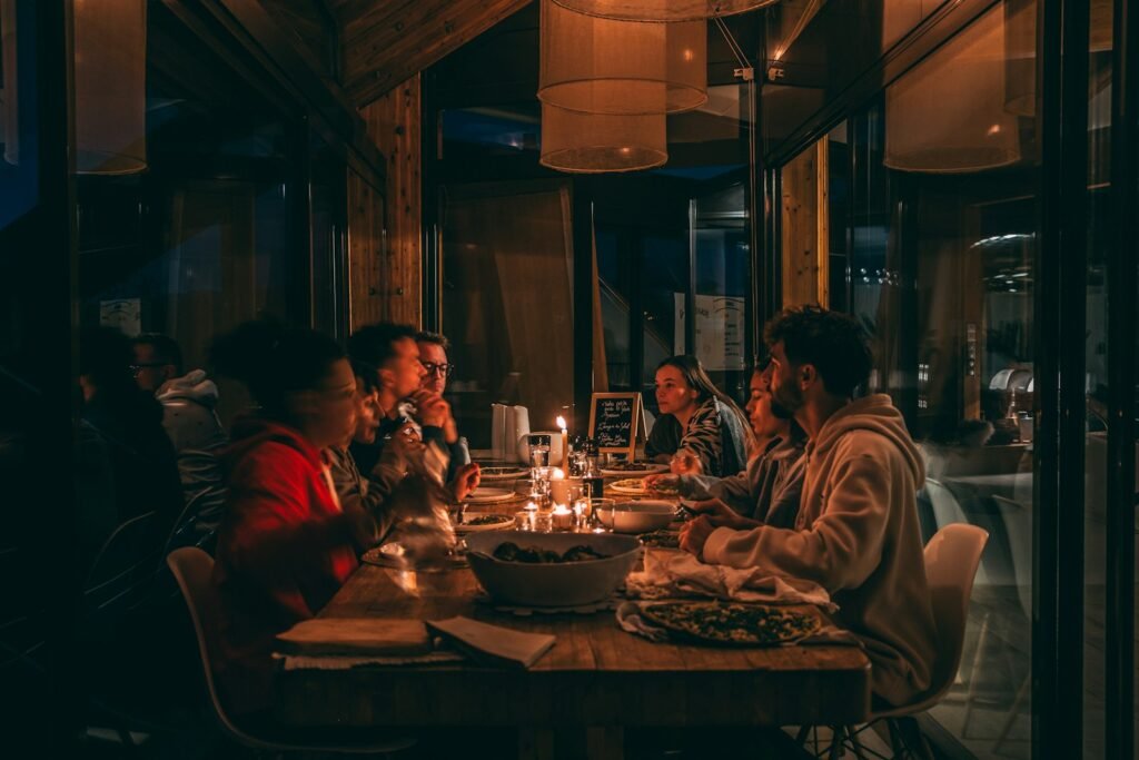 People enjoying a candlelit dinner at a dimly lit restaurant for a milestone celebration