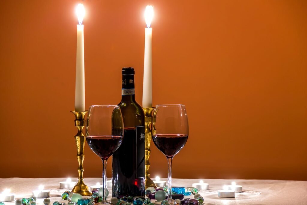 Cozy candlelit dinner setting with red wine and elegant glasses