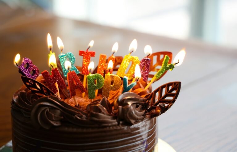 Chocolate cake with lit happy birthday candles for a milestone celebration