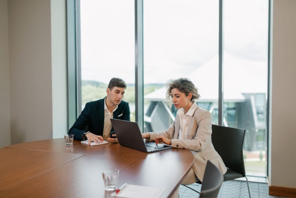 Two colleagues engaged in a business meeting in a well-lit modern office