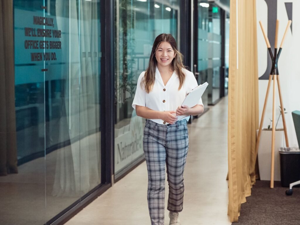 Confident woman walking through a modern office hallway