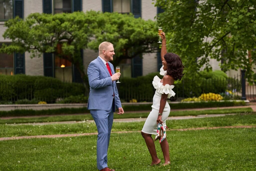 Couple celebrating their engagement with a champagne toast in a garden setting