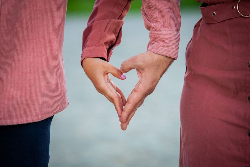 Close-up of a couple forming a heart shape with their hands