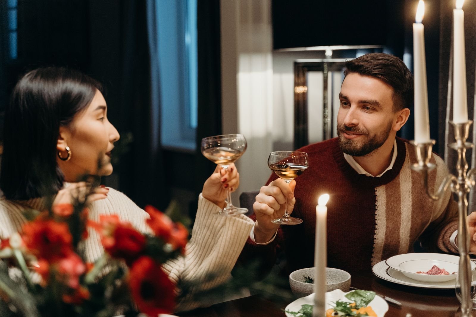 Couple enjoying a romantic dinner with candles and flowers