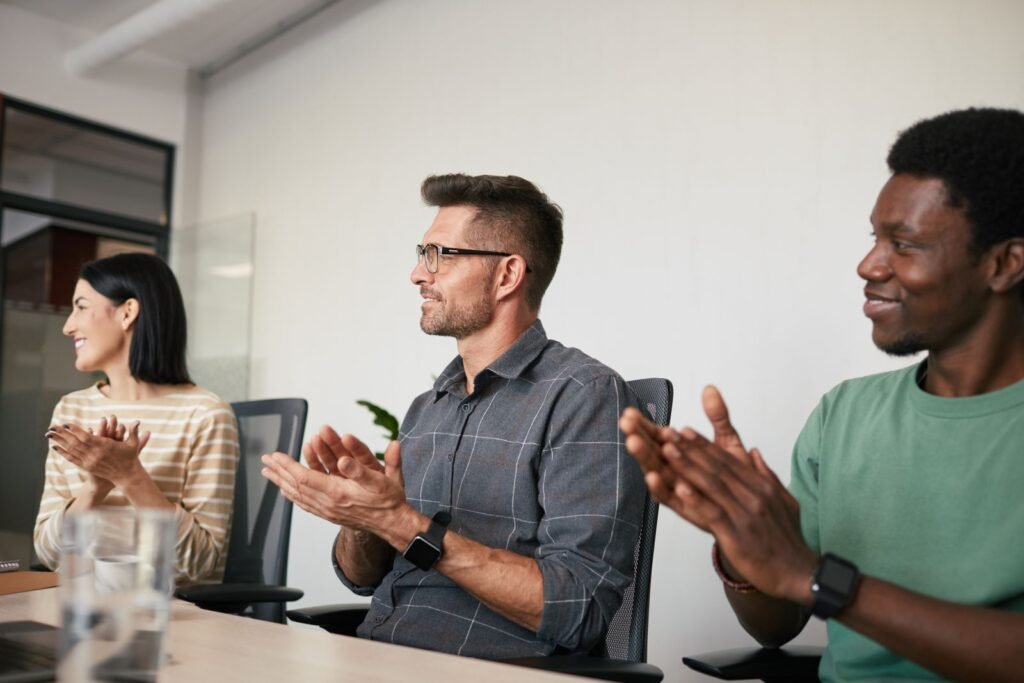 A diverse group of coworkers applauding during an office meeting