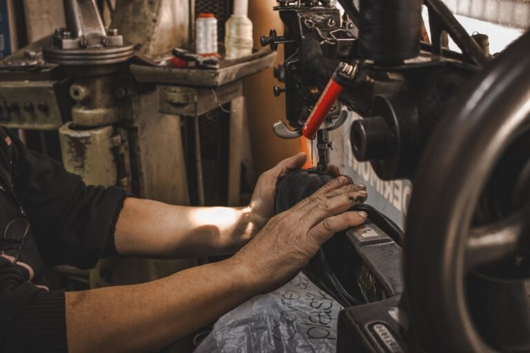 Close-up of a craftsman's hands operating a vintage industrial sewing machine