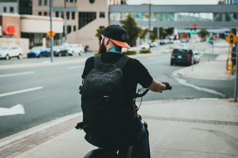 A cyclist with a backpack rides through a city street, showcasing urban commuting lifestyle