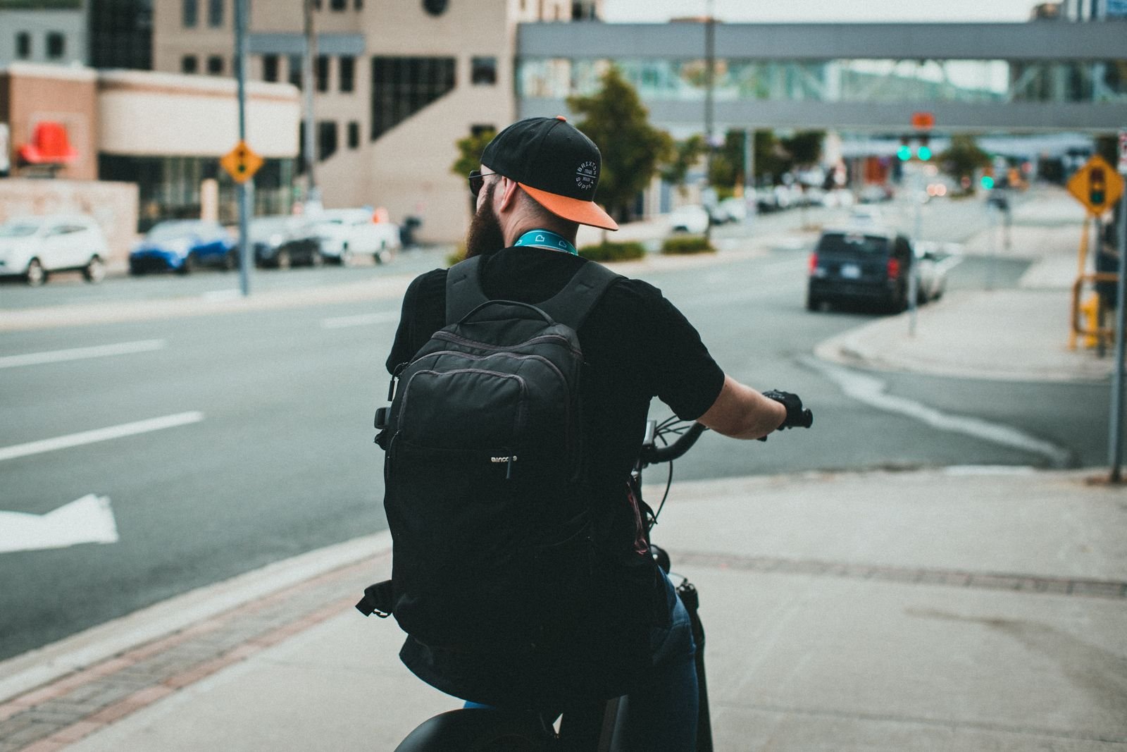 A cyclist with a backpack rides through a city street, showcasing urban commuting lifestyle