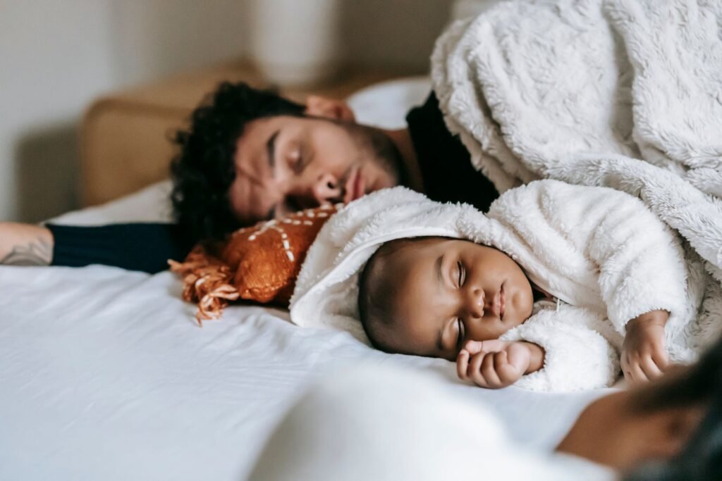 Father and newborn baby lying and sleeping together