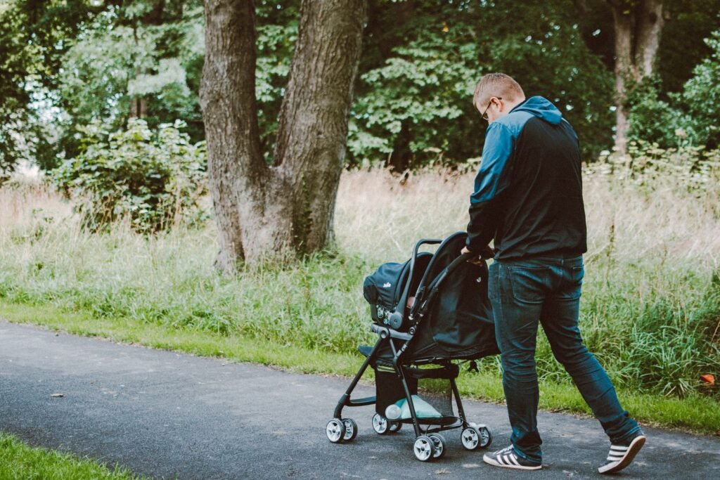 A father pushing a stroller on a park pathway