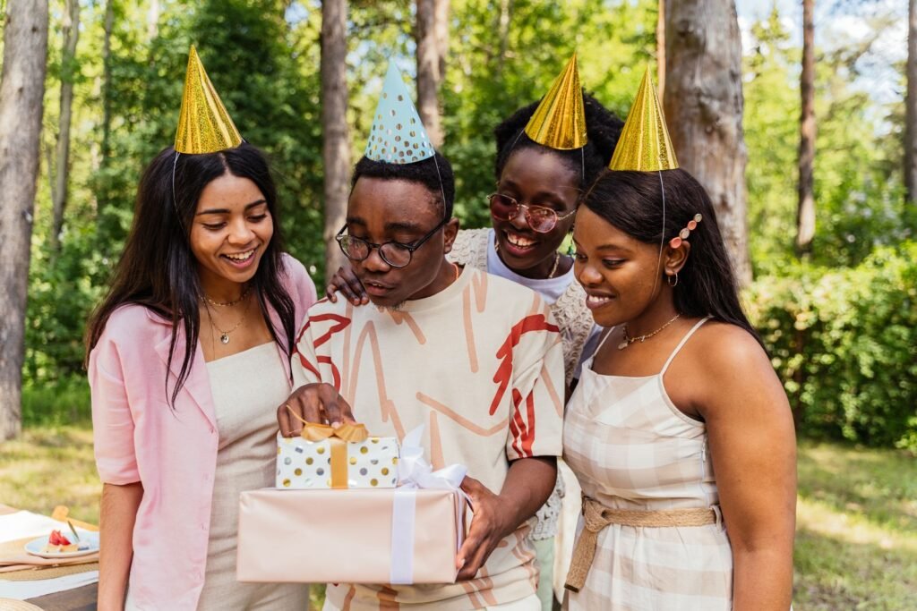 Group of friends celebrating a birthday outdoors with gifts