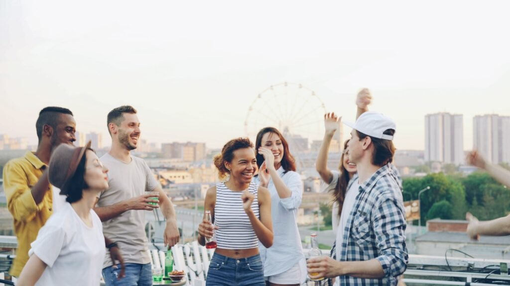 Group of friends dancing and celebrating together on a rooftop