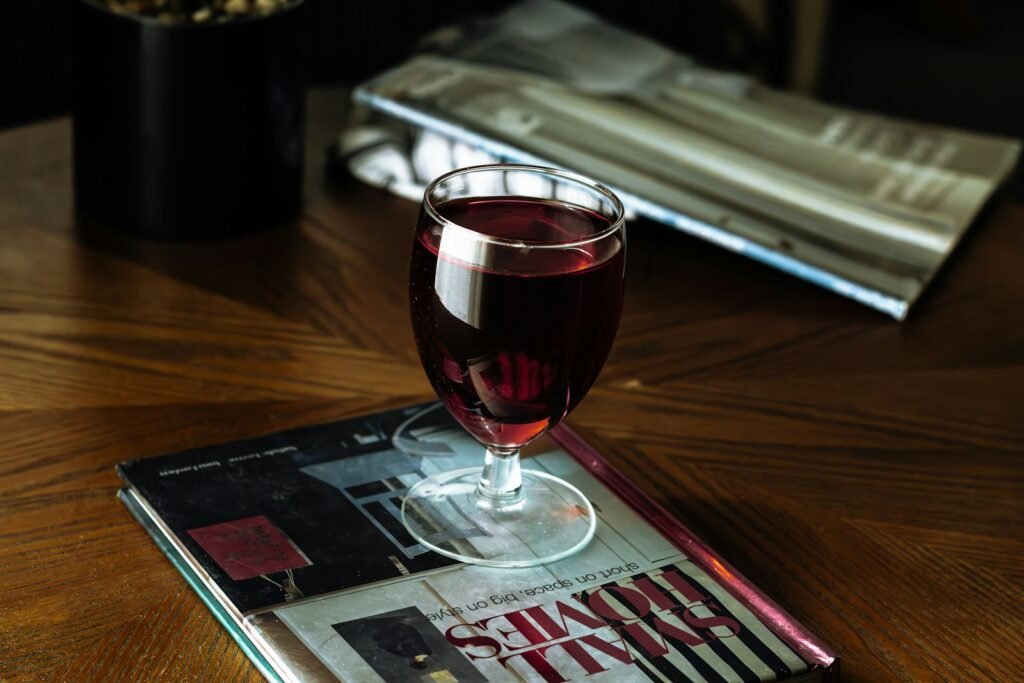 Glass of red wine sitting on top of a magazine, a common leather stain risk
