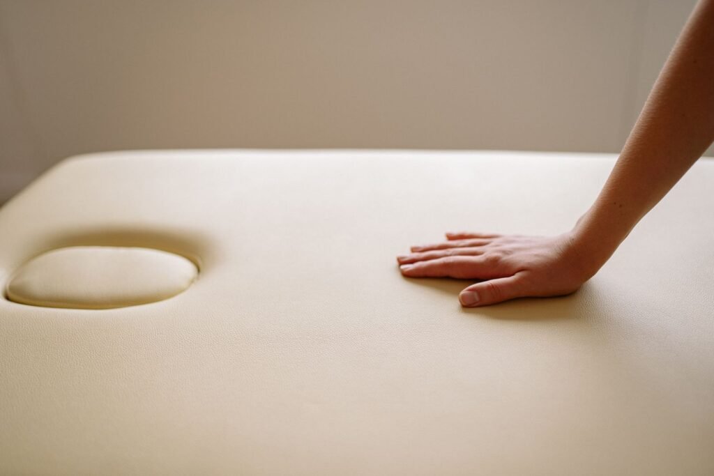 Close-up of a hand gently pressing on a soft leather surface