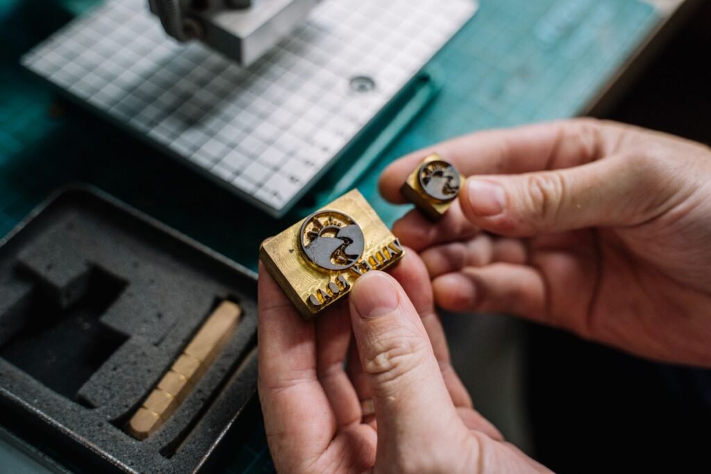 Close-up view of hands holding handcrafted brass stamps
