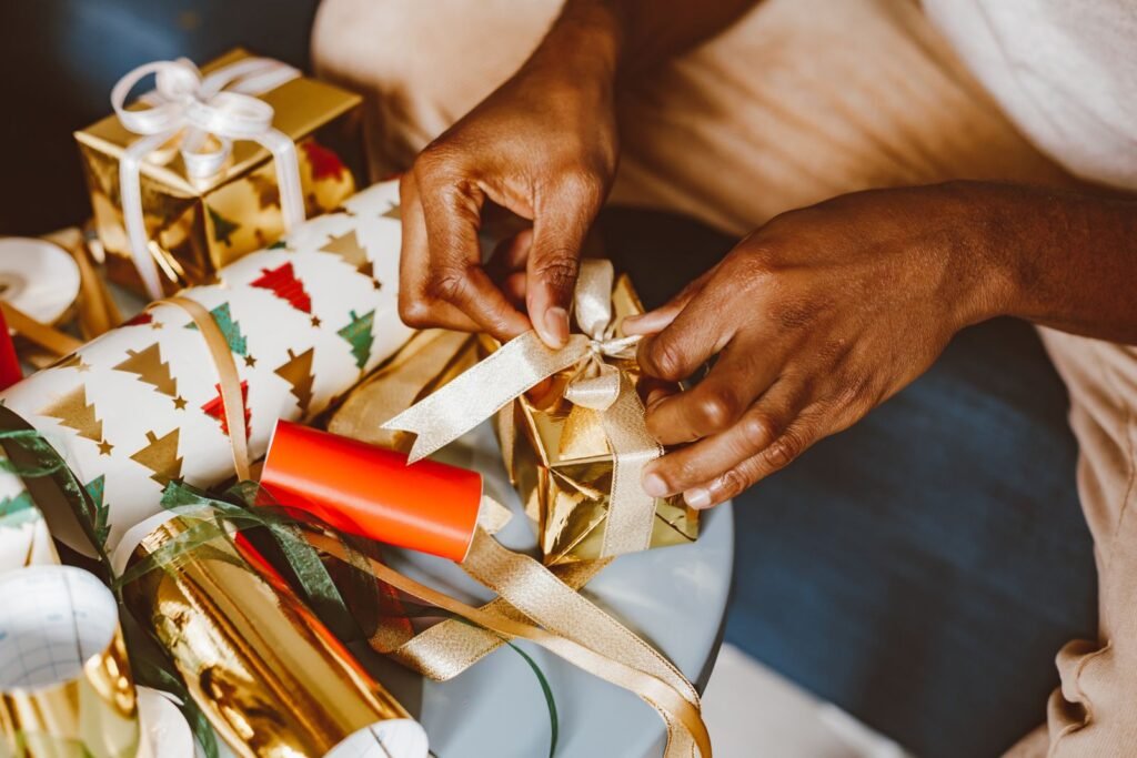 Hands tying ribbon while wrapping a gift