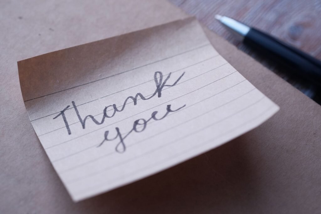 Close-up of a handwritten thank you note on brown paper