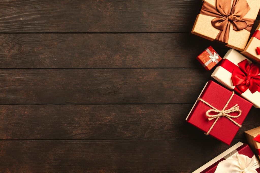 Decorative holiday gift boxes with ribbons on a rustic wooden table