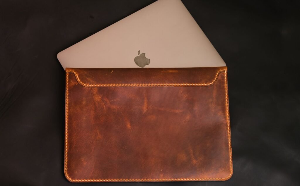 Close-up of a laptop resting in a stylish brown leather case