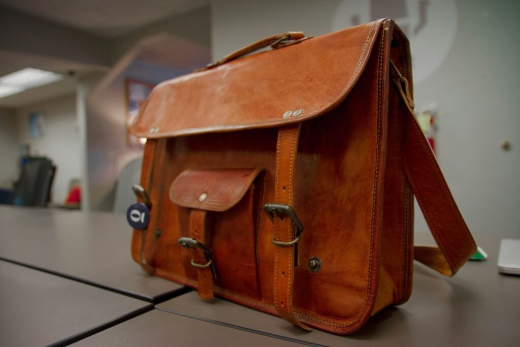 Close-up of a brown leather bag strap and buckle hardware