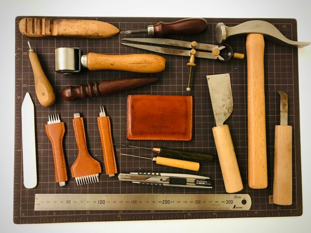 Variety of leather craftsman tools laid out on a cutting board