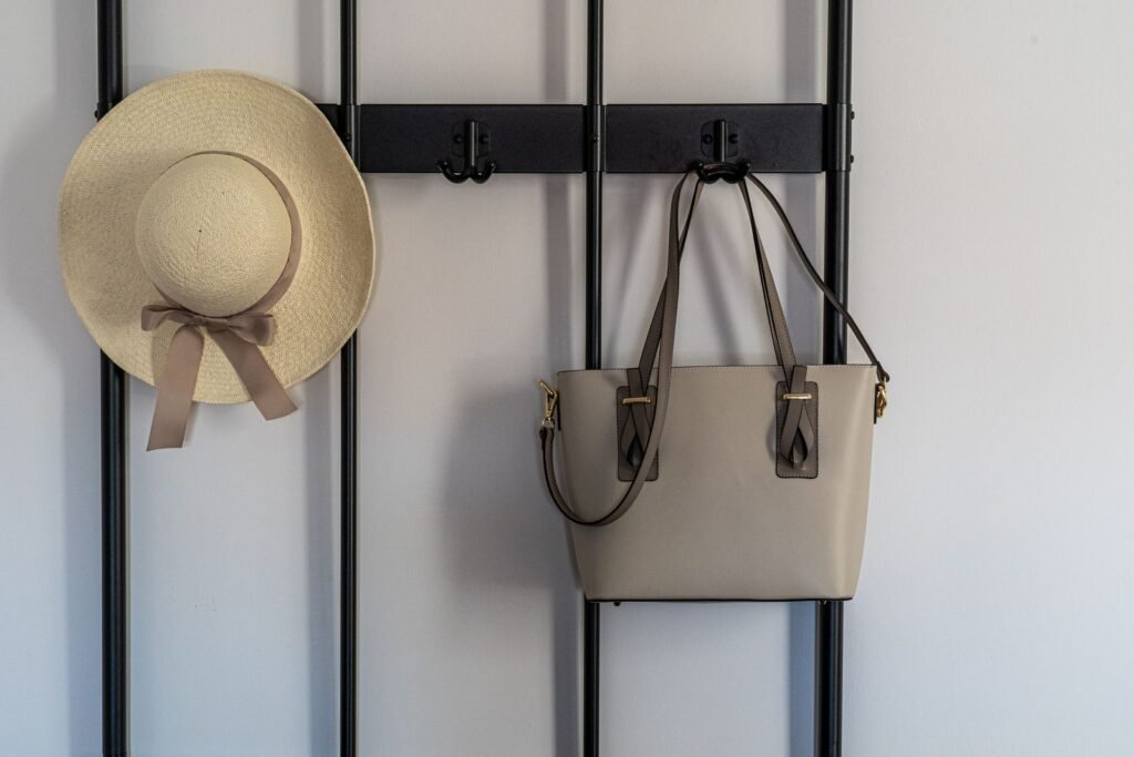 A stylish leather handbag hanging on a modern wall hook indoors