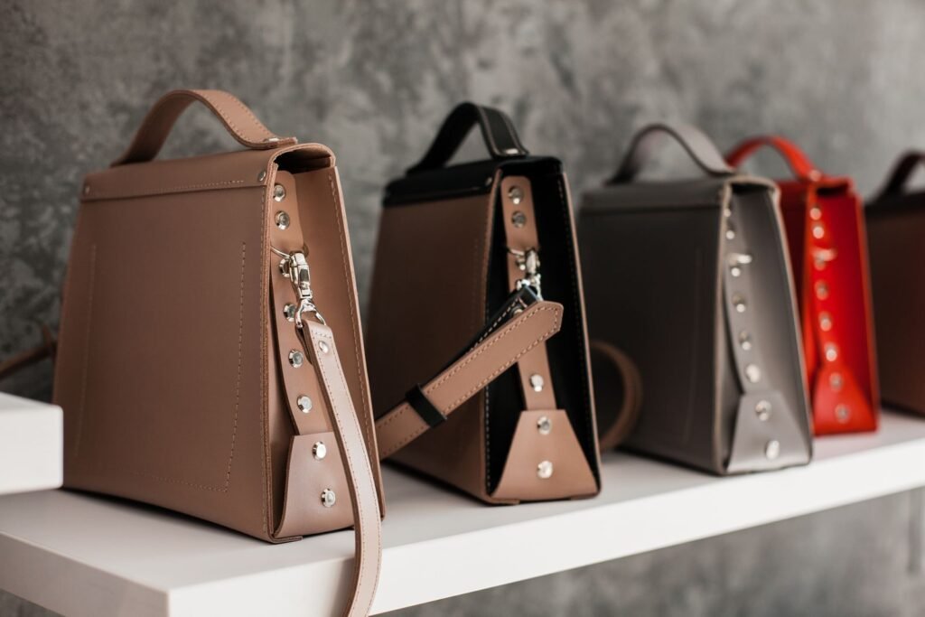 Luxury leather handbags displayed on a white shelf