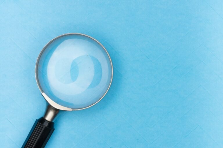 Magnifying glass resting on a white table, used for close inspection