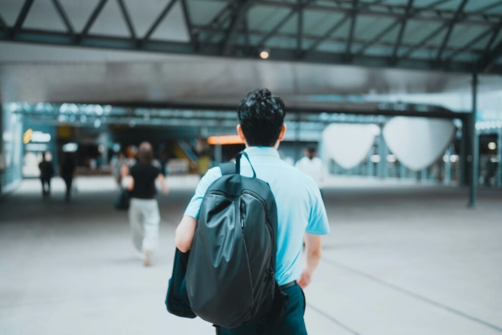 Man with a single backpack walking through a modern building