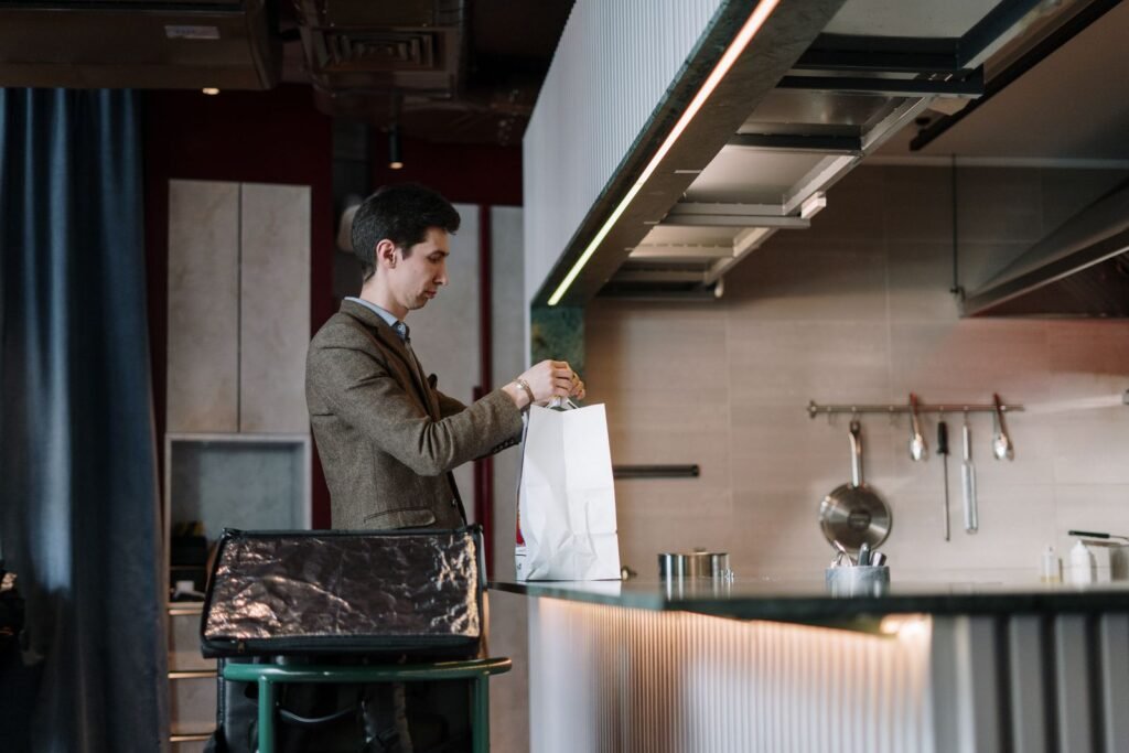 Man meticulously packing a bag at a kitchen counter in the morning