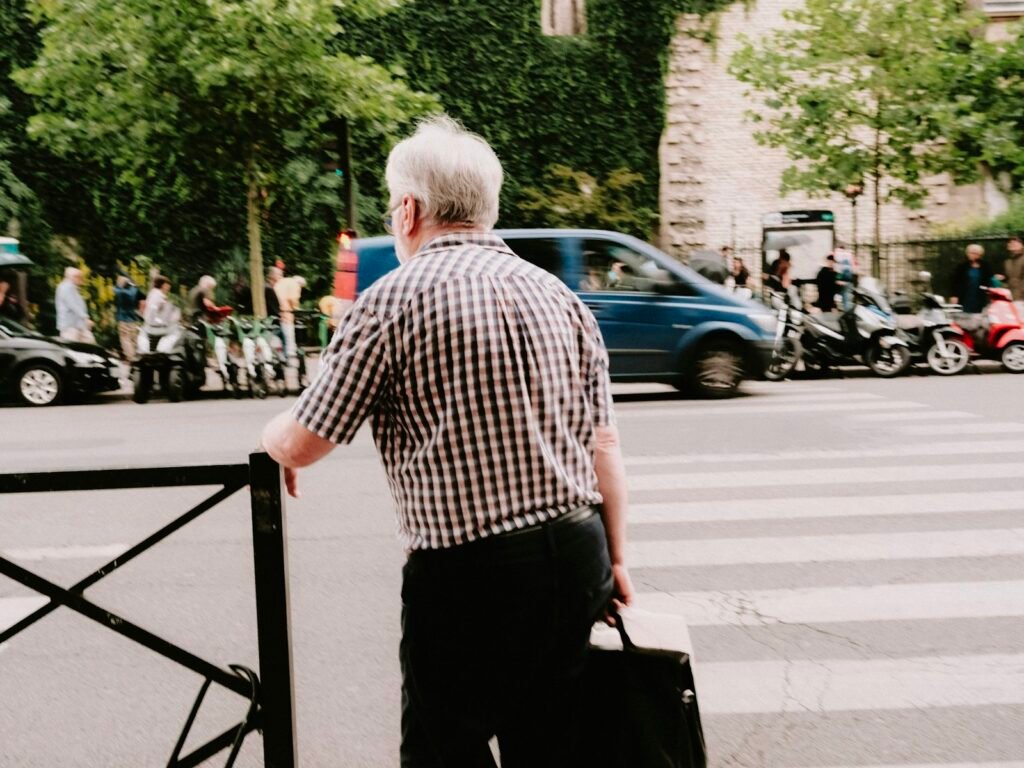 Man walking across a street with a suitcase, ready for post-retirement travel