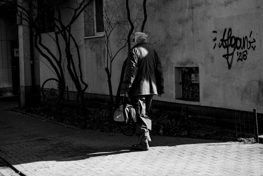 Man walking away from the camera carrying a bag over his shoulder