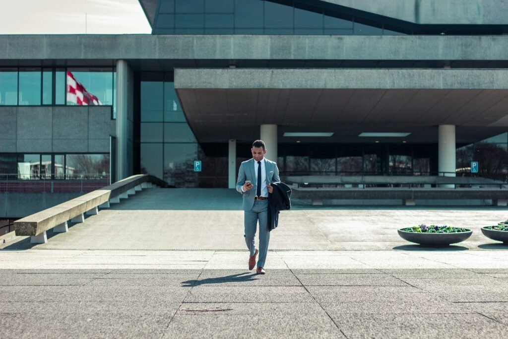 Man walking while holding a black coat in a professional setting