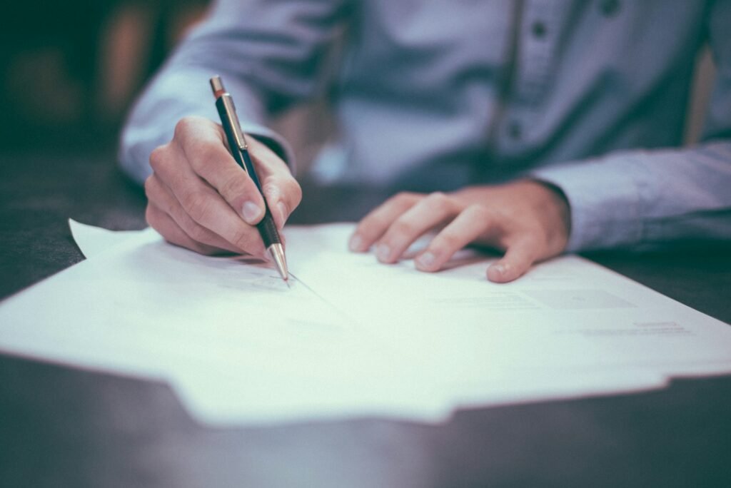 Man writing and signing a paper document