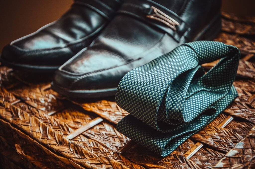 Close-up of a stylish necktie resting next to polished leather shoes