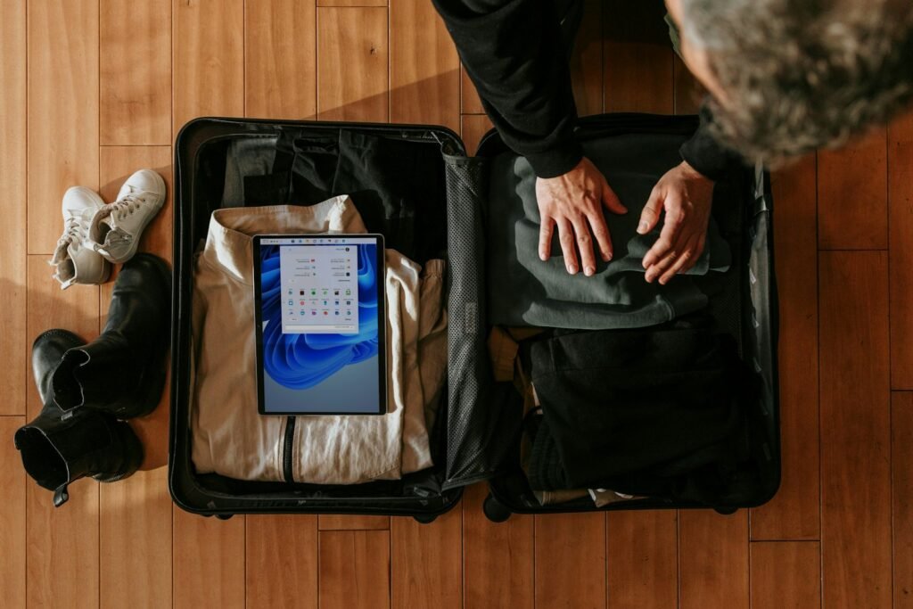 Overhead view of a person packing a suitcase for a trip