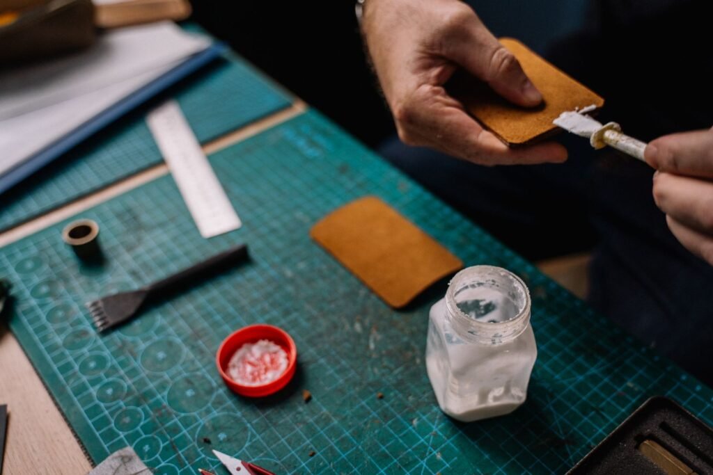 A detailed close-up of a person applying glue on leather for repair
