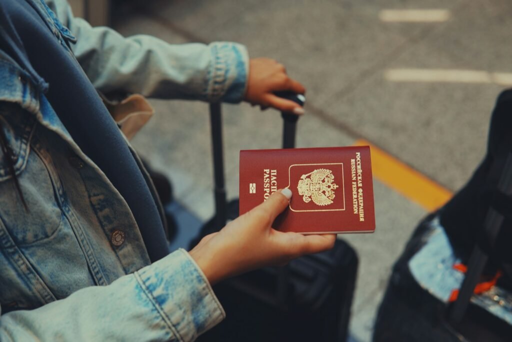 Person holding a red passport in their hand, ready for a border crossing