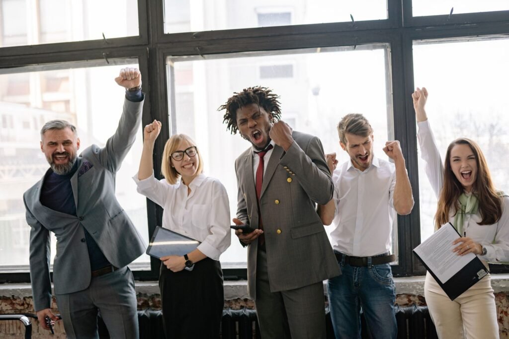 Group of diverse professionals celebrating achievement in an office setting
