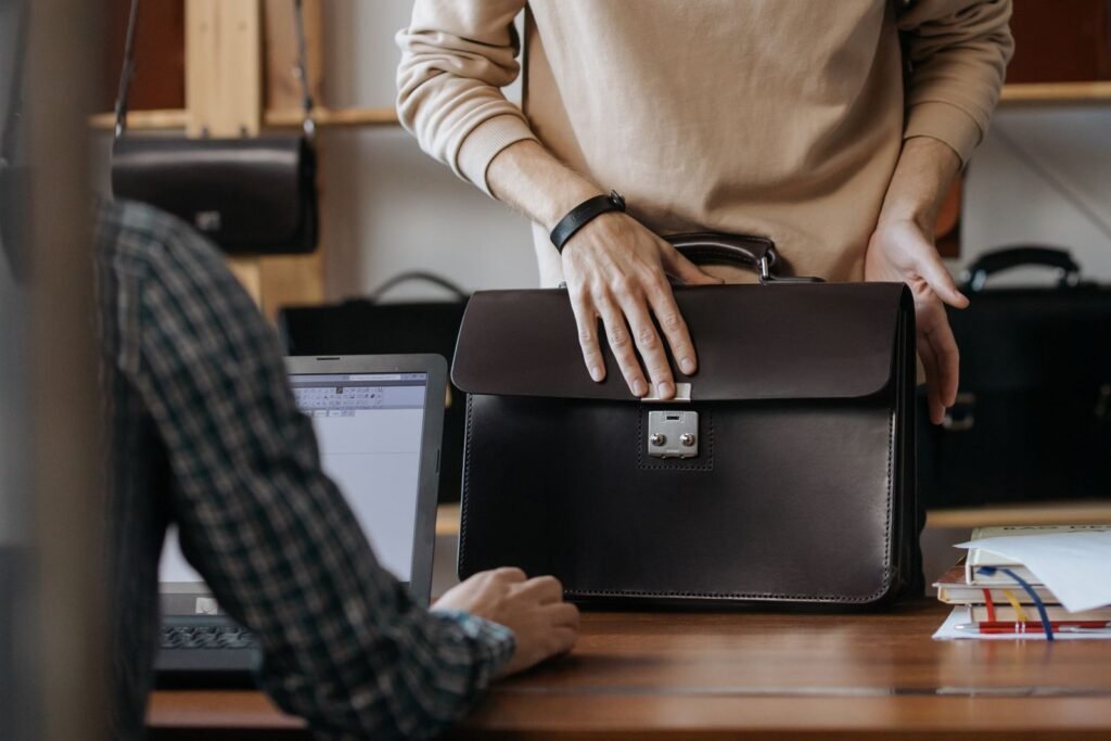 Close-up of two professionals handling a leather briefcase in an office setting