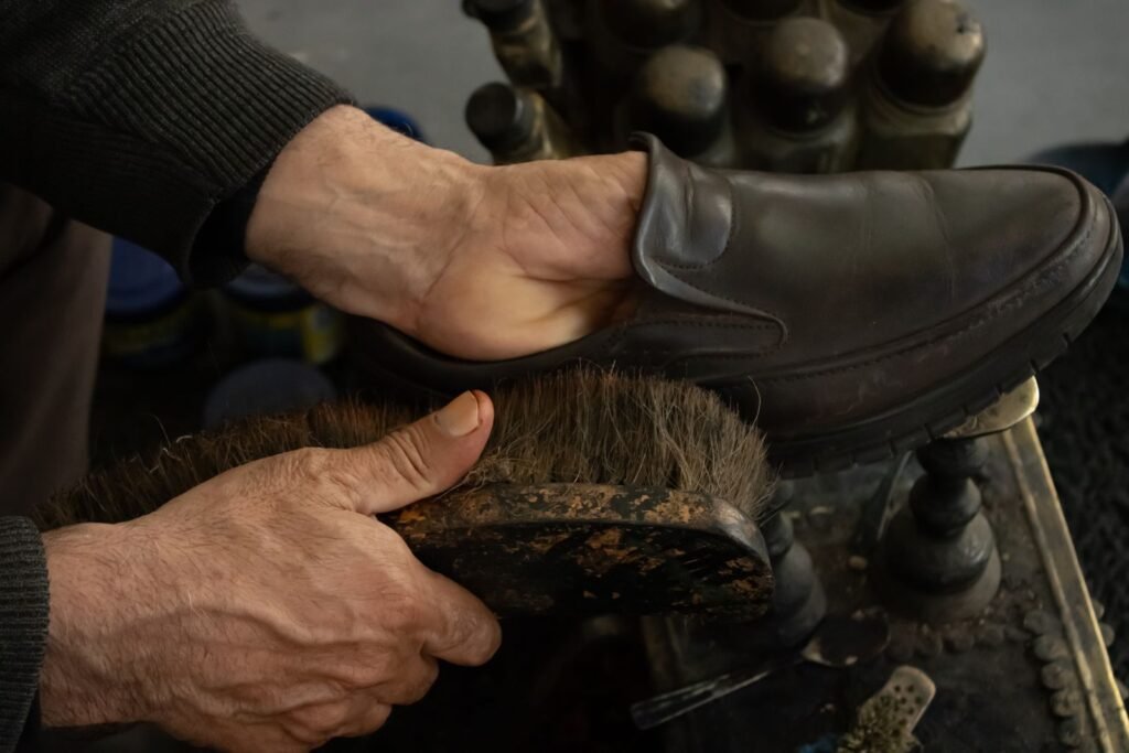 Detailed view of a shoe being polished by hand using a brush
