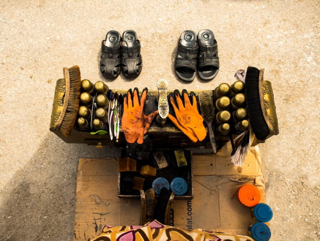 Aerial view of a shoe shine setup with brushes, polish, and gloves