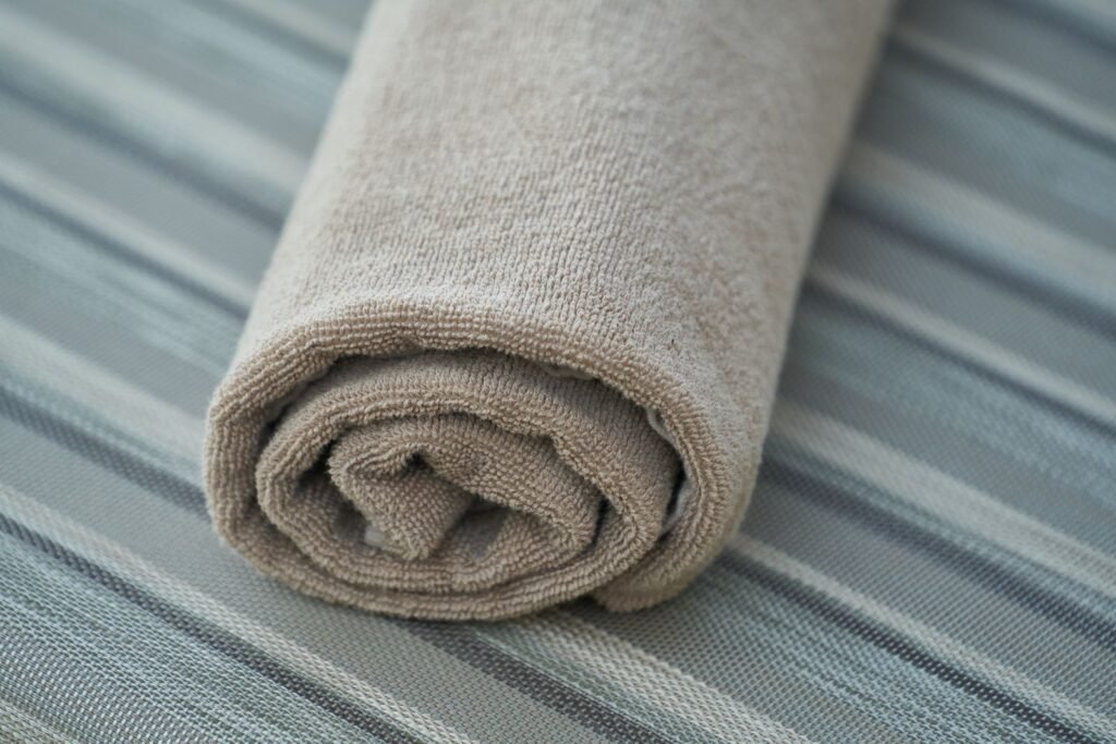 Close-up of a soft beige cotton towel rolled neatly